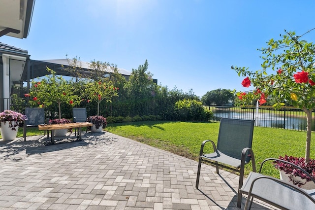 view of patio / terrace featuring a water view and fence