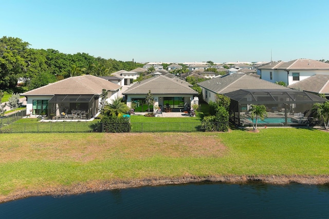 exterior space featuring a residential view, a water view, a lawn, and a fenced backyard