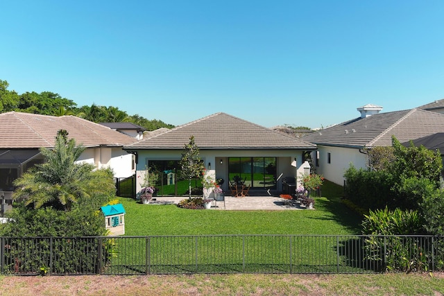 back of house featuring a yard, a fenced backyard, stucco siding, and a tiled roof