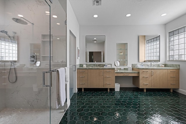 full bathroom featuring visible vents, a marble finish shower, a sink, and a wealth of natural light