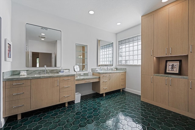 bathroom featuring a sink, recessed lighting, and two vanities