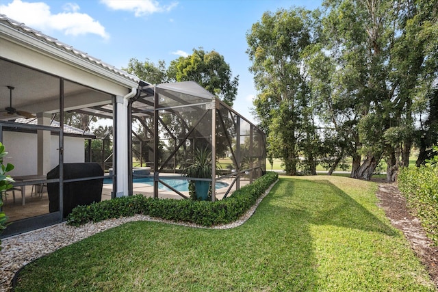 view of yard with ceiling fan and an outdoor pool