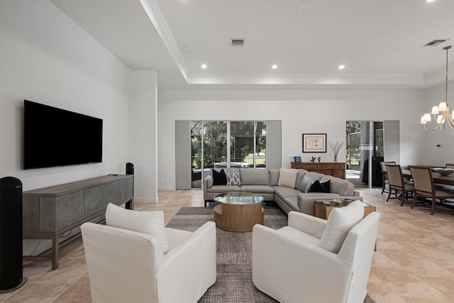 living area featuring visible vents, recessed lighting, a tray ceiling, and a chandelier