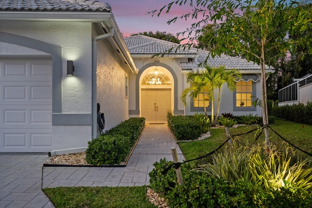 9637 Spray Dr, West Palm Beach, FL 33411 - exterior entry at dusk featuring stucco siding and a tile roof