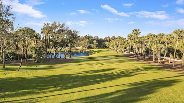 view of home's community with a yard, a water view, and golf course view