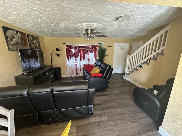 living area featuring visible vents, stairs, wood finished floors, a textured ceiling, and a ceiling fan