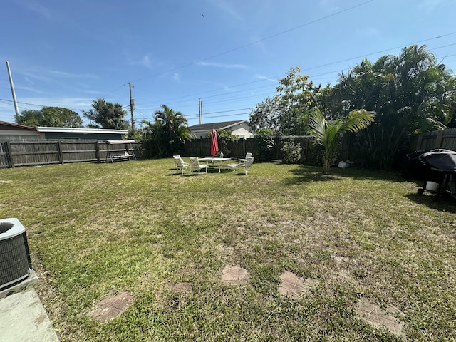 view of yard featuring central AC unit and a fenced backyard