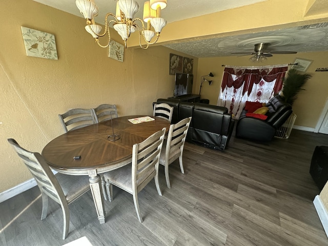 dining area with ceiling fan with notable chandelier, wood finished floors, baseboards, and a textured wall