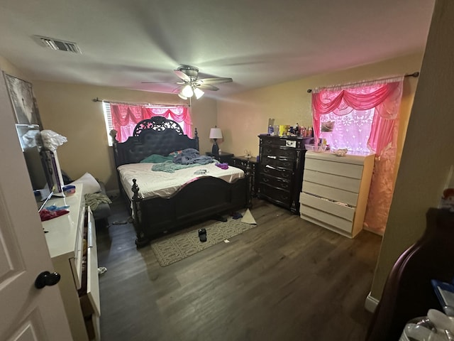 bedroom featuring visible vents, dark wood-style floors, and a ceiling fan