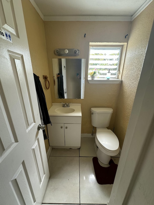 half bath with vanity, ornamental molding, tile patterned flooring, toilet, and a textured wall