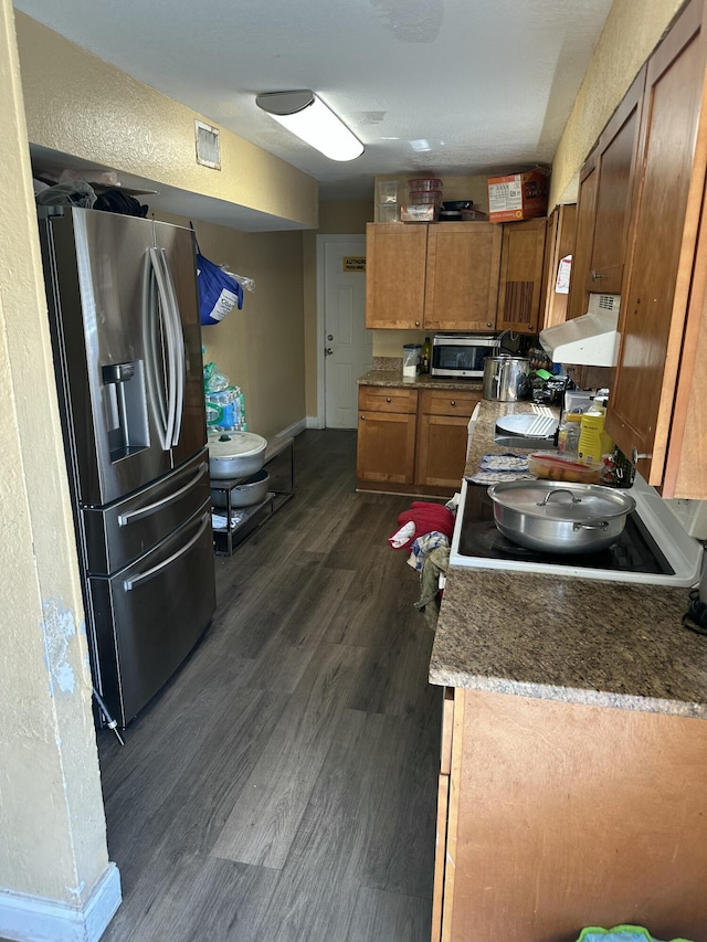 kitchen with visible vents, brown cabinetry, exhaust hood, dark wood-style floors, and stainless steel appliances