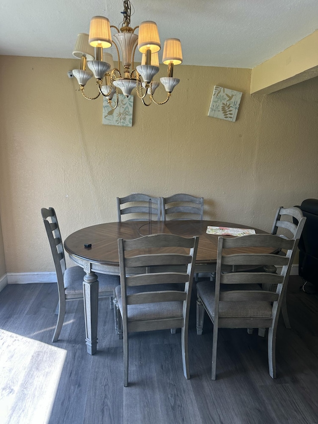 dining room featuring wood finished floors, baseboards, a textured wall, and a chandelier