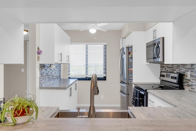 7240 Huntington Ln Unit 802, Delray Beach, FL 33446 - kitchen featuring white cabinetry, tasteful backsplash, stainless steel appliances, a sink, and a ceiling fan
