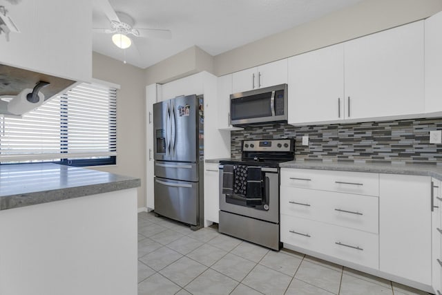 7240 Huntington Ln Unit 802, Delray Beach, FL 33446 - kitchen featuring ceiling fan, appliances with stainless steel finishes, white cabinetry, backsplash, and light tile patterned floors