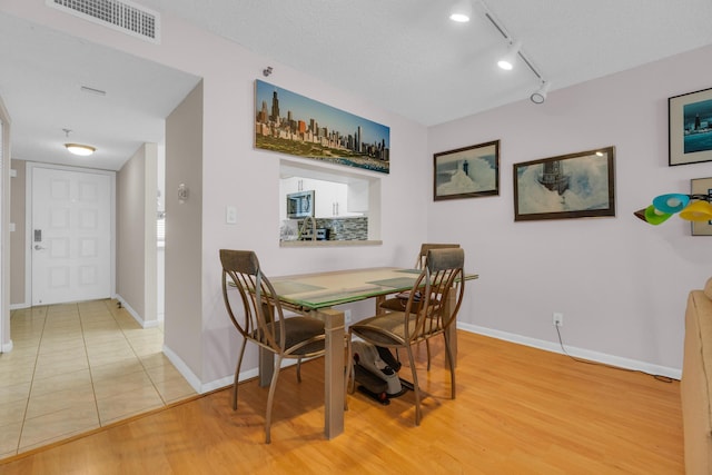 7240 Huntington Ln Unit 802, Delray Beach, FL 33446 - dining space featuring baseboards, track lighting, visible vents, and light wood-style floors