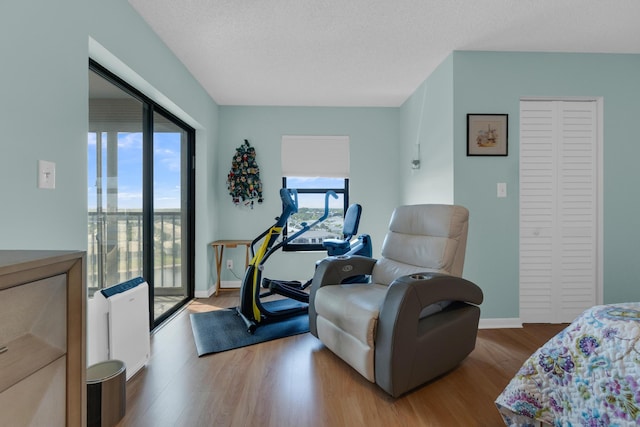 7240 Huntington Ln Unit 802, Delray Beach, FL 33446 - bedroom featuring baseboards, a textured ceiling, access to exterior, and wood finished floors