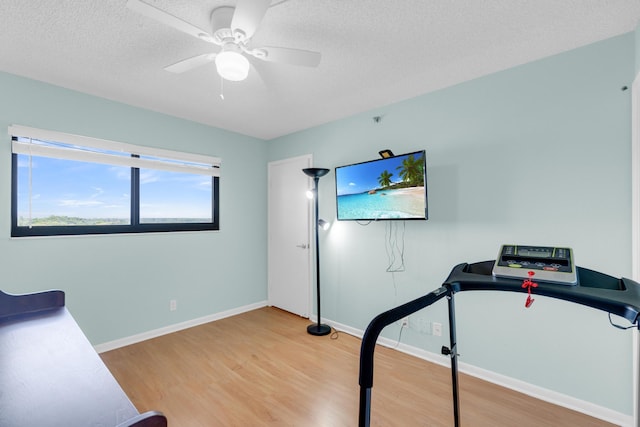 7240 Huntington Ln Unit 802, Delray Beach, FL 33446 - exercise room featuring baseboards, light wood-type flooring, ceiling fan, and a textured ceiling