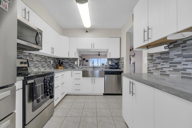 7240 Huntington Ln Unit 802, Delray Beach, FL 33446 - kitchen with white cabinetry, light tile patterned floors, decorative backsplash, a sink, and appliances with stainless steel finishes