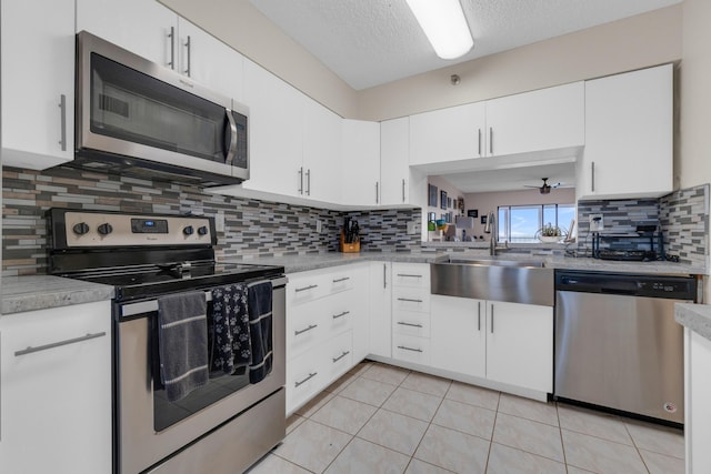 7240 Huntington Ln Unit 802, Delray Beach, FL 33446 - kitchen featuring light countertops, a sink, appliances with stainless steel finishes, light tile patterned floors, and white cabinets