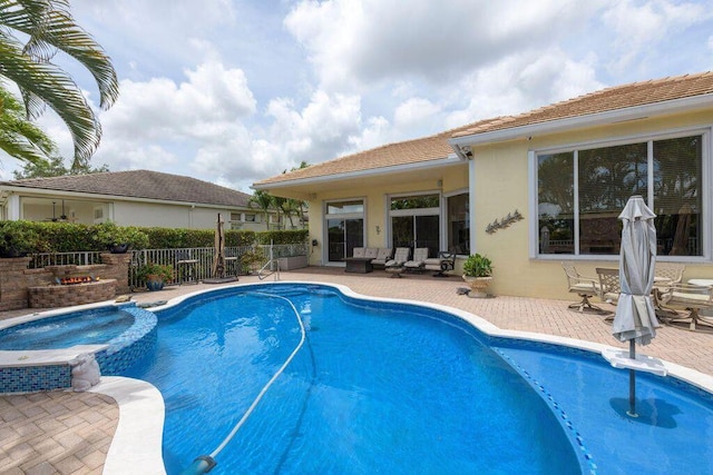 view of swimming pool featuring a patio, fence, and a pool with connected hot tub