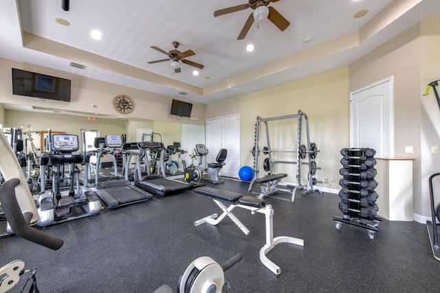 workout area featuring visible vents, a tray ceiling, recessed lighting, baseboards, and ceiling fan