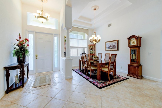 entryway with visible vents, baseboards, a chandelier, light tile patterned flooring, and ornate columns