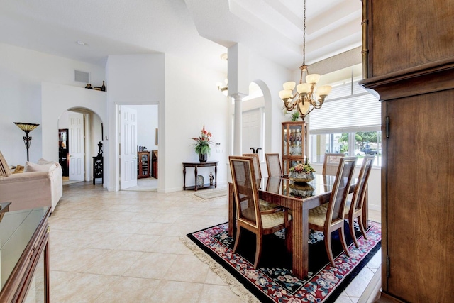 dining area with visible vents, arched walkways, a high ceiling, an inviting chandelier, and light tile patterned floors