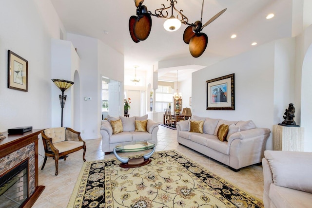 living area featuring light tile patterned floors, recessed lighting, a chandelier, and a fireplace