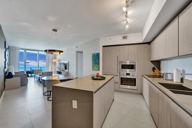 kitchen featuring a kitchen island, light tile patterned flooring, stainless steel appliances, floor to ceiling windows, and modern cabinets