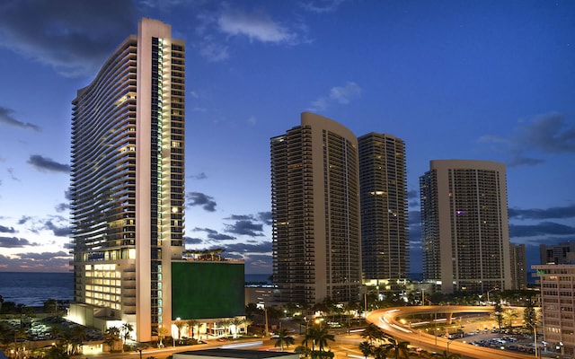 property at dusk featuring a view of city and a water view