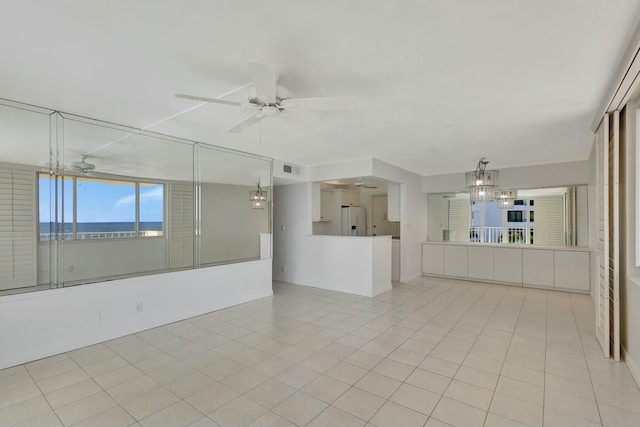 empty room with ceiling fan with notable chandelier