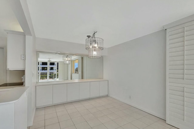 unfurnished dining area featuring light tile patterned floors and an inviting chandelier