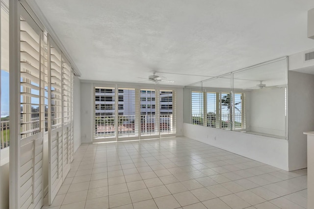 empty room with light tile patterned floors, visible vents, and a ceiling fan