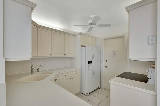 kitchen featuring light tile patterned floors, a ceiling fan, a sink, light countertops, and white fridge with ice dispenser