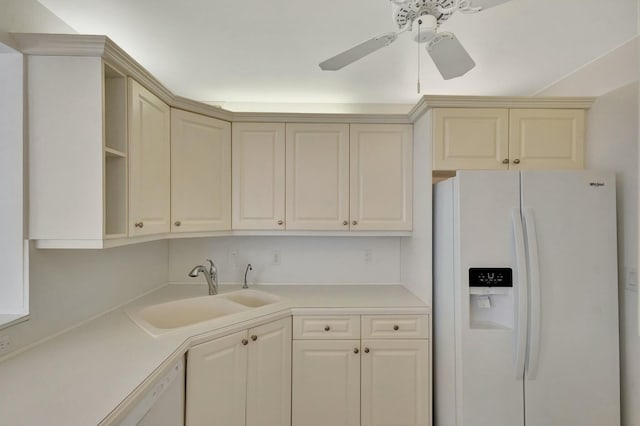 kitchen with light countertops, white fridge with ice dispenser, cream cabinetry, a ceiling fan, and a sink