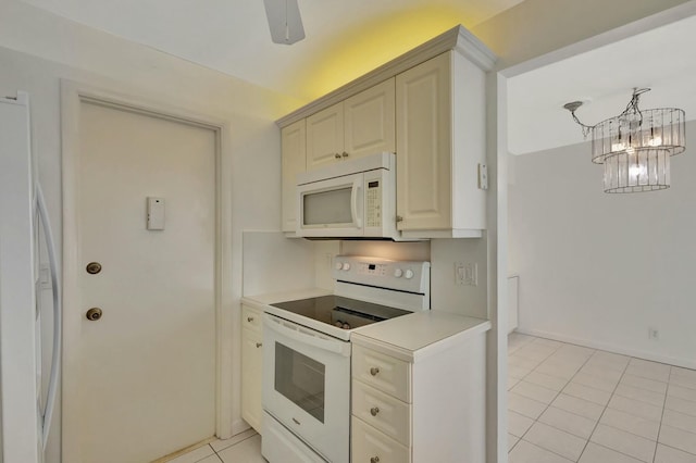 kitchen featuring baseboards, a chandelier, light countertops, light tile patterned flooring, and white appliances