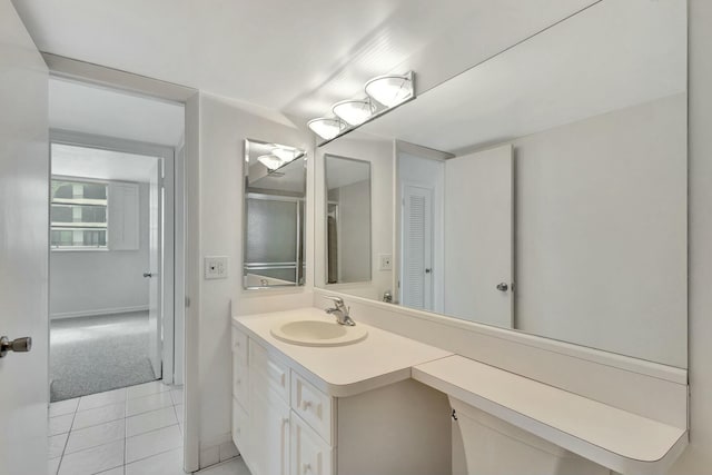 bathroom featuring vanity, baseboards, and tile patterned flooring