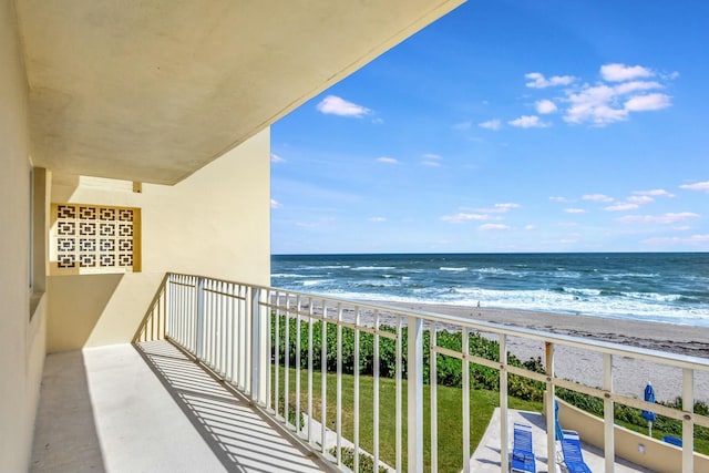 balcony with a water view and a beach view