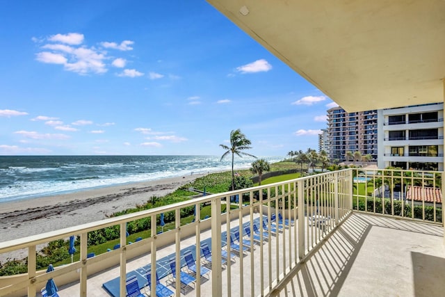 balcony featuring a water view and a view of the beach