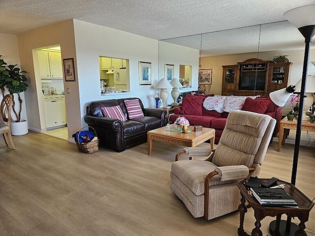 living room with a textured ceiling and light wood-type flooring