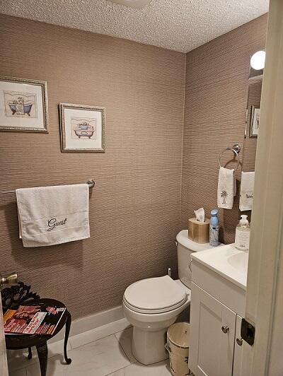 bathroom with baseboards, toilet, vanity, and a textured ceiling