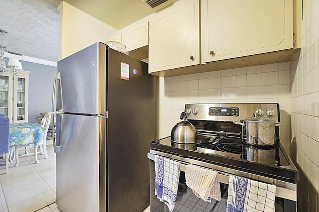 kitchen featuring light tile patterned floors, white cabinets, appliances with stainless steel finishes, a textured ceiling, and tasteful backsplash