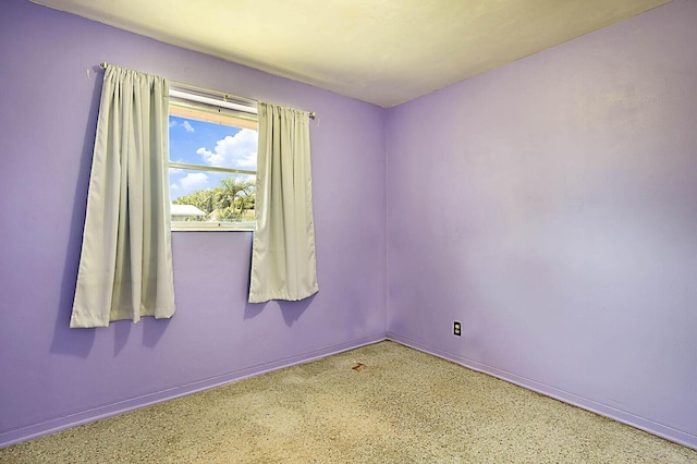 unfurnished room with baseboards