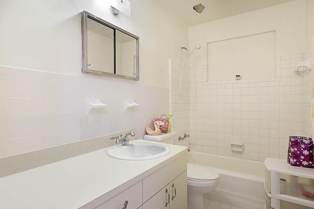 full bath with tile walls, toilet, shower / bathtub combination, tile patterned floors, and vanity