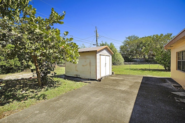 exterior space featuring an outbuilding, a storage unit, and fence