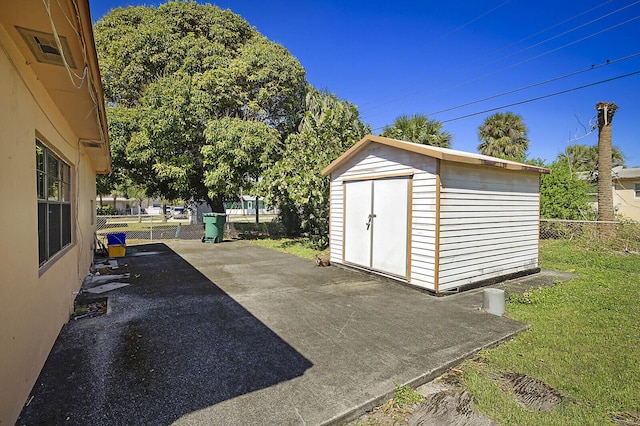 view of patio / terrace with a fenced backyard, a storage unit, and an outdoor structure