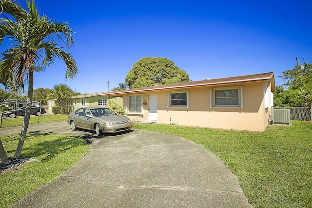 ranch-style house with central AC unit, stucco siding, and a front yard