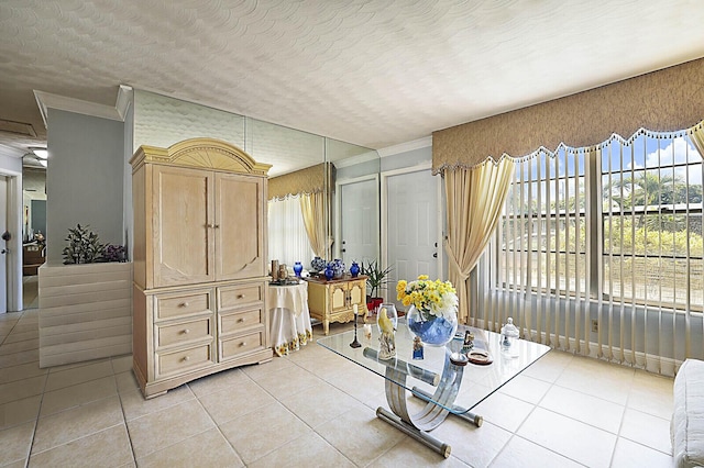 interior space featuring light tile patterned floors, a textured ceiling, and crown molding