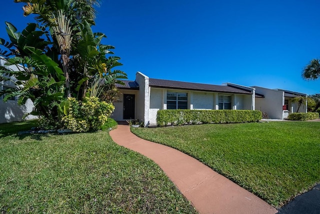 single story home featuring a front lawn and stucco siding