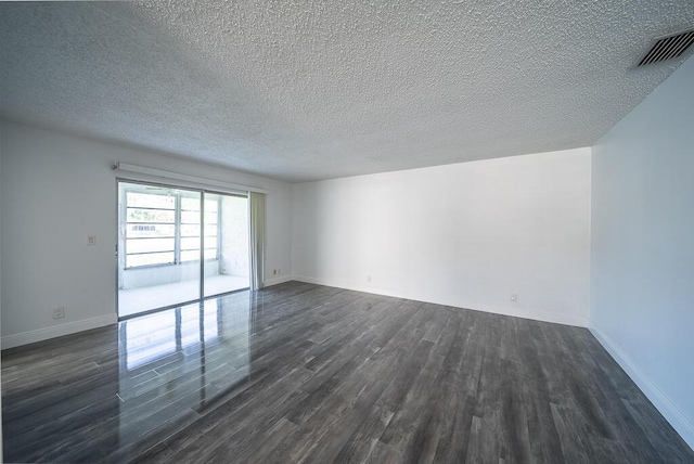 unfurnished room featuring baseboards, visible vents, dark wood-style flooring, and a textured ceiling